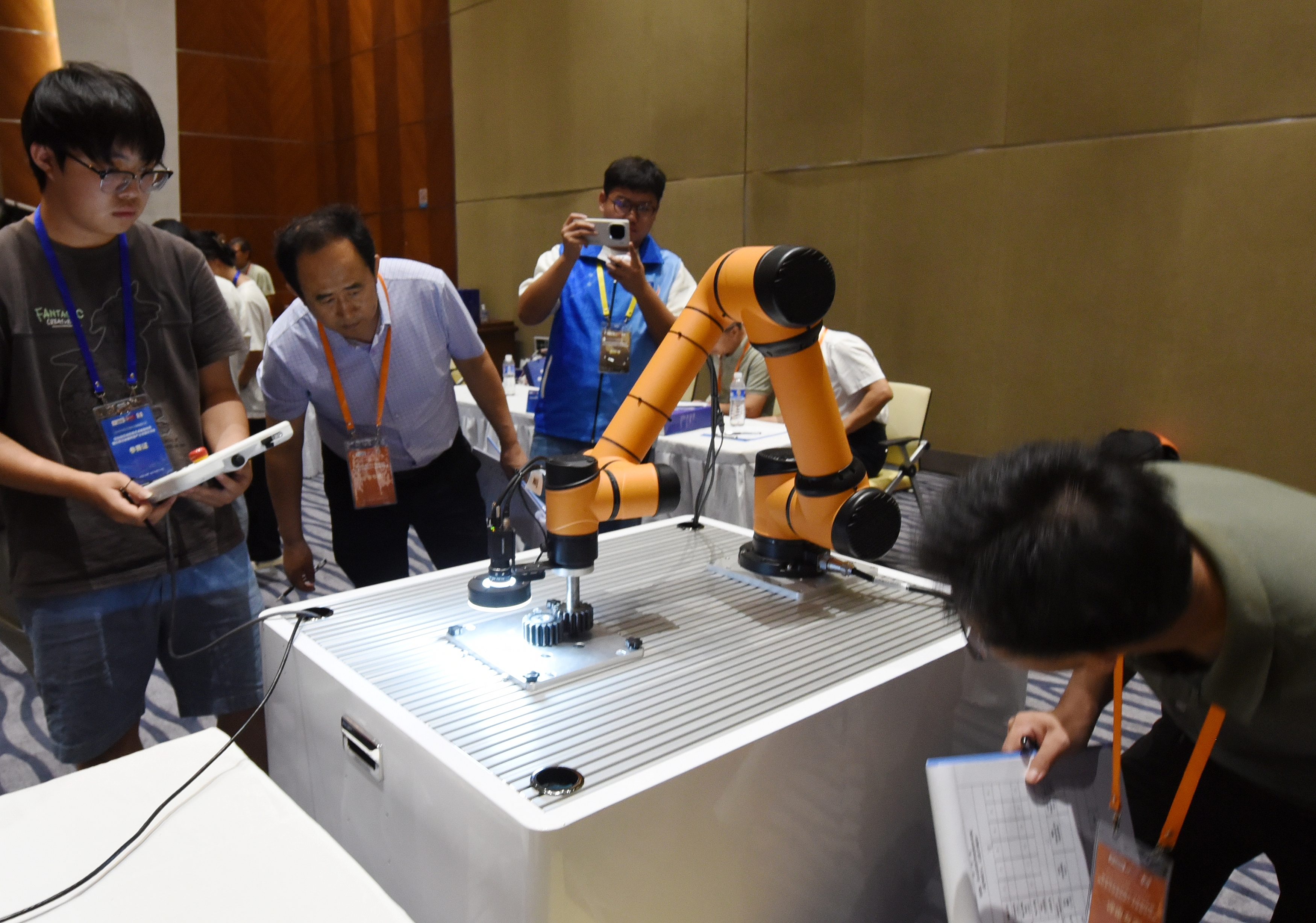 2025年中國(guó)大學(xué)生機(jī)械工程創(chuàng)新創(chuàng)意大賽智能精密裝配賽京津冀魯聯(lián)賽現(xiàn)場(chǎng)，評(píng)委對(duì)參賽選手進(jìn)行實(shí)操調(diào)試評(píng)比。